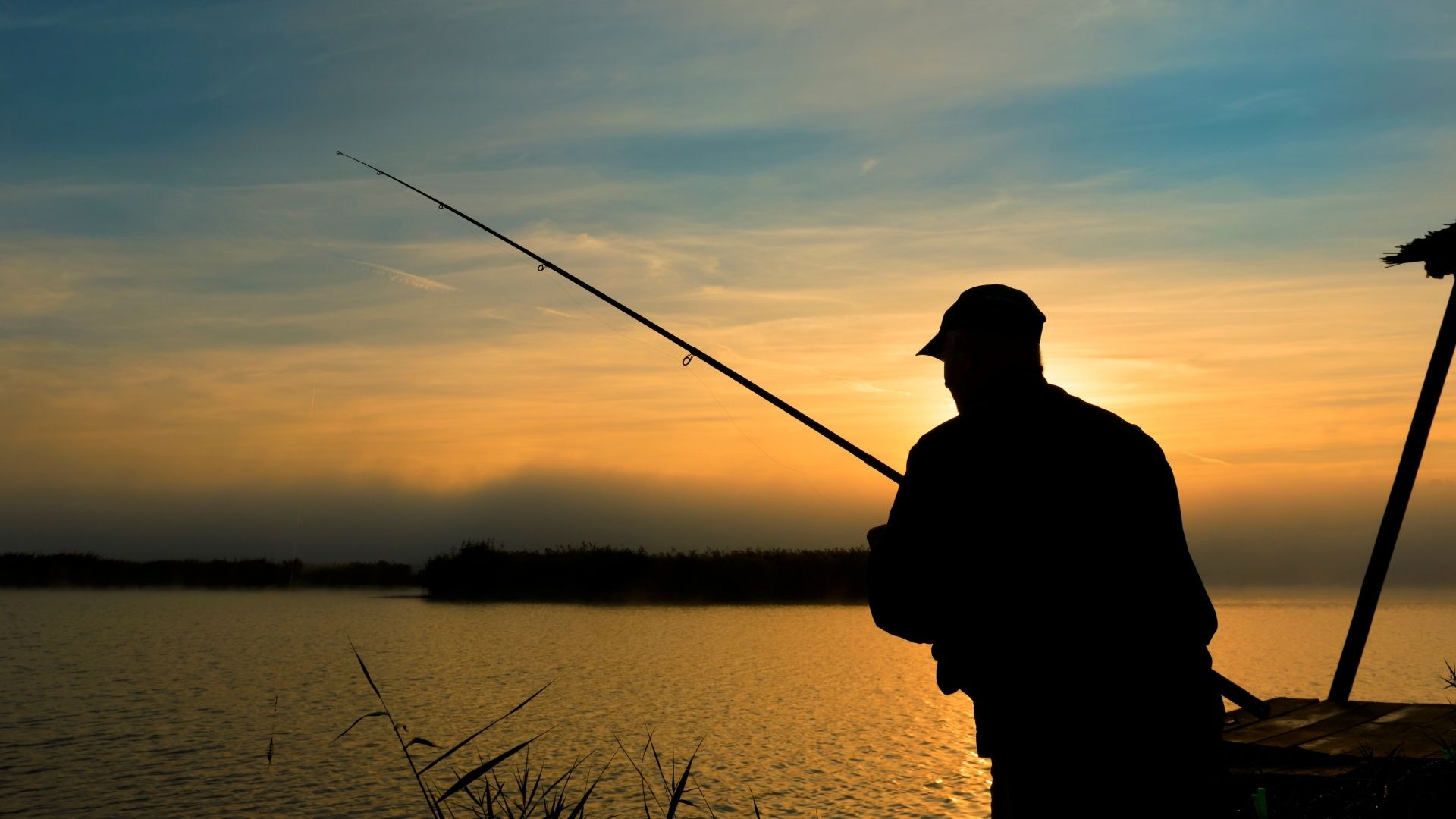 Angler fishing on the river at dusk